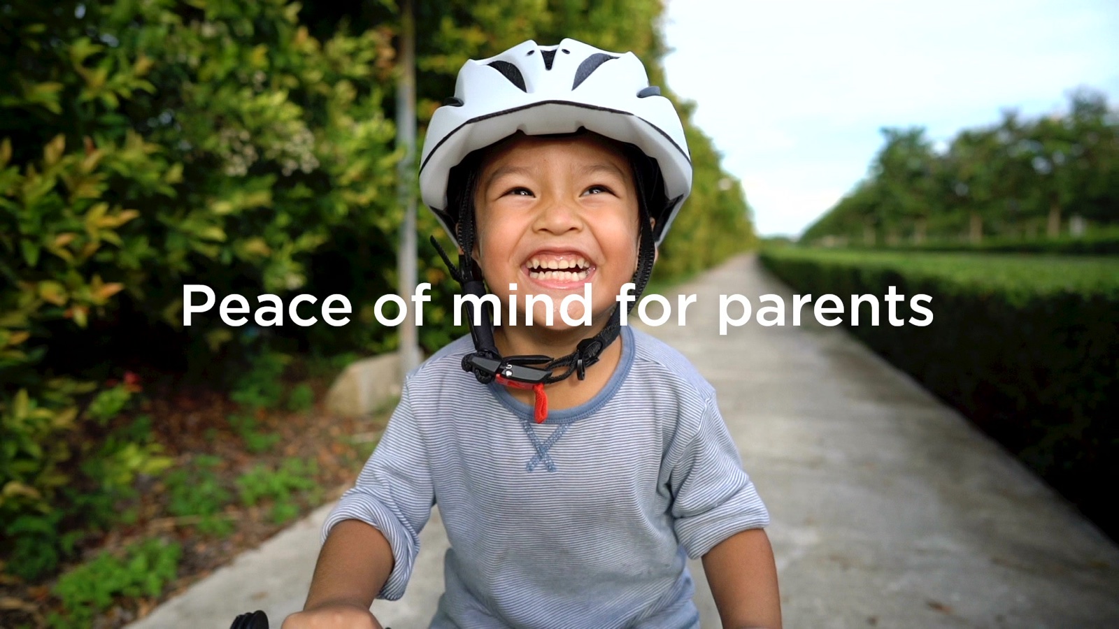 Smiling child in a bike helmet with the headline Peace of mind for parents