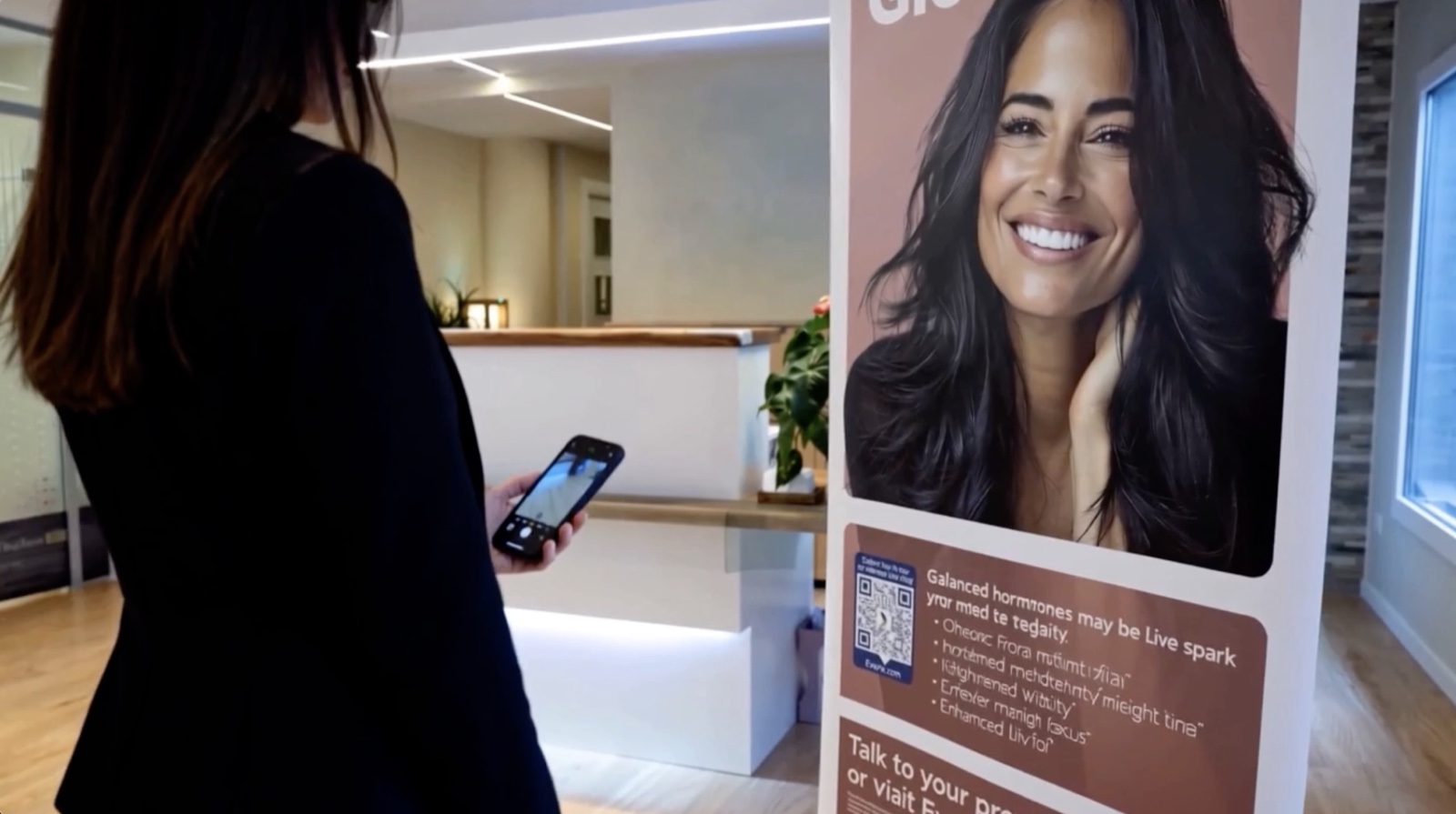 Patient in EVEXIAS clinic scanning a Connect QR code on a branded retractable banner